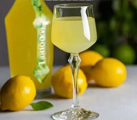 A bottle of Limoncello served in elegant glasses with fresh lemons.